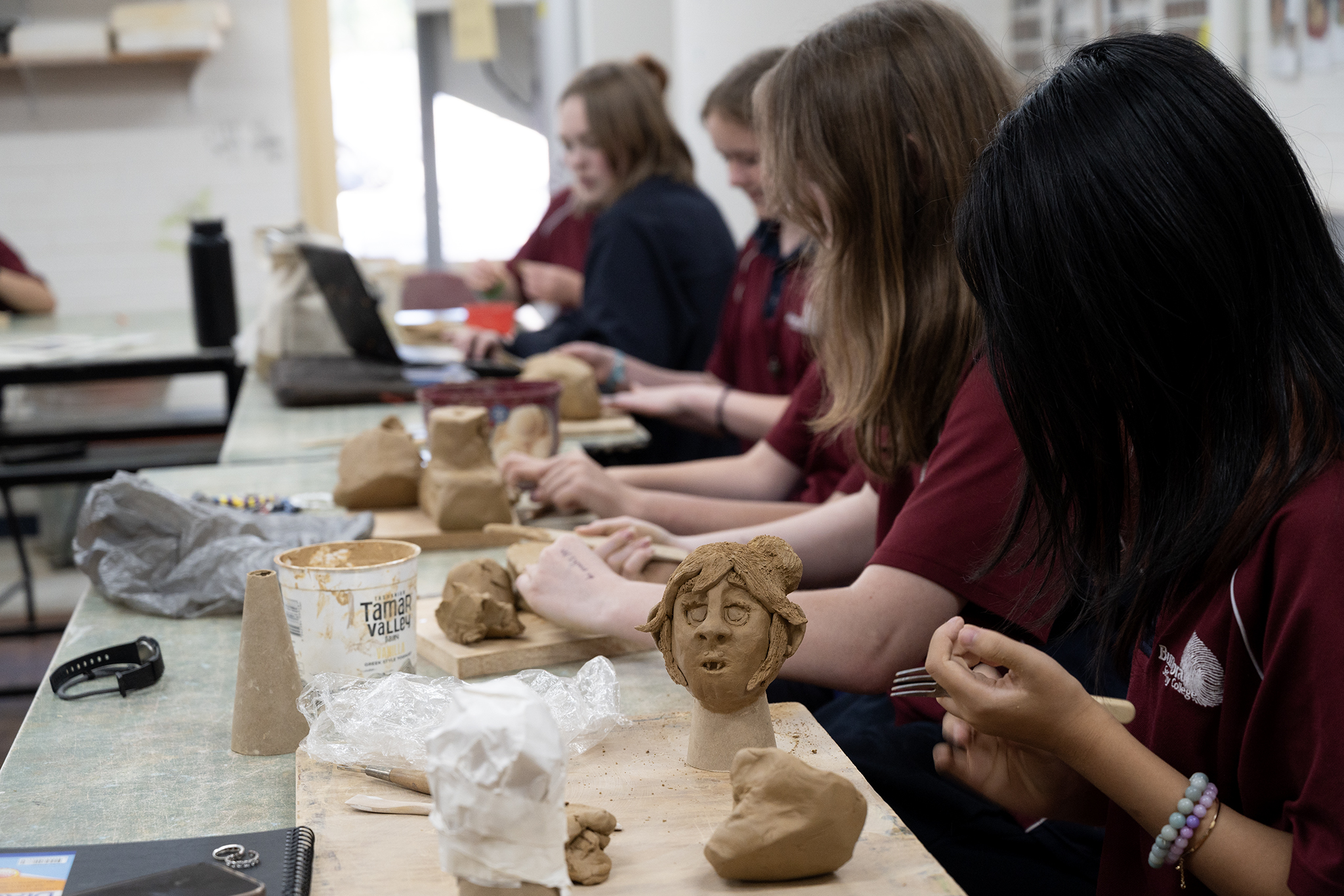 Students making artwork out of clay in art class