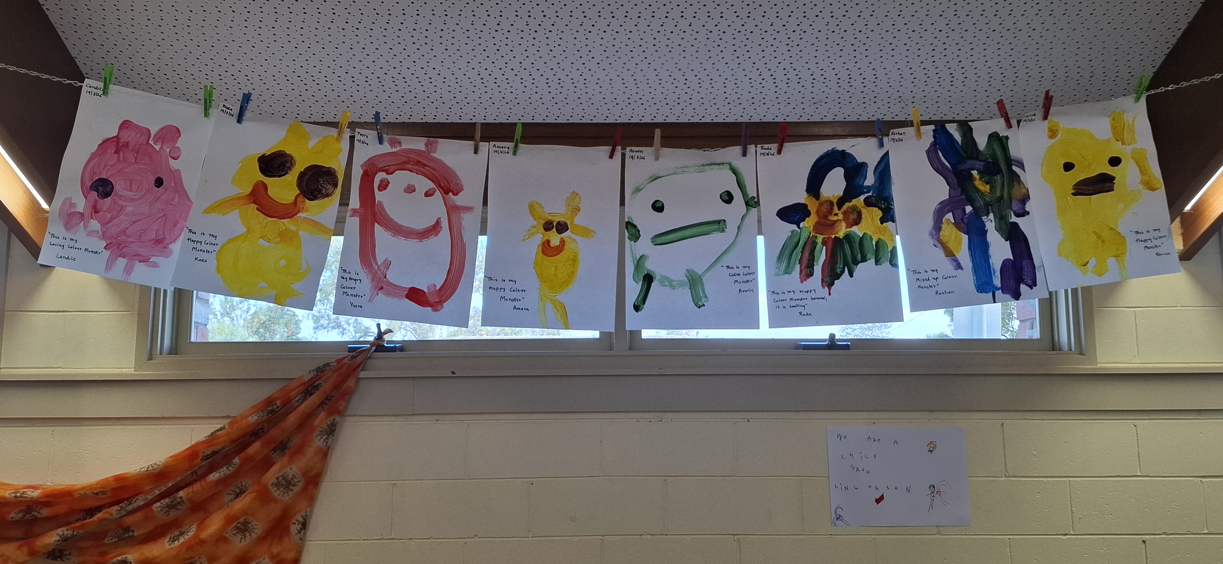Paintings of colour monsters hanging on a line for display