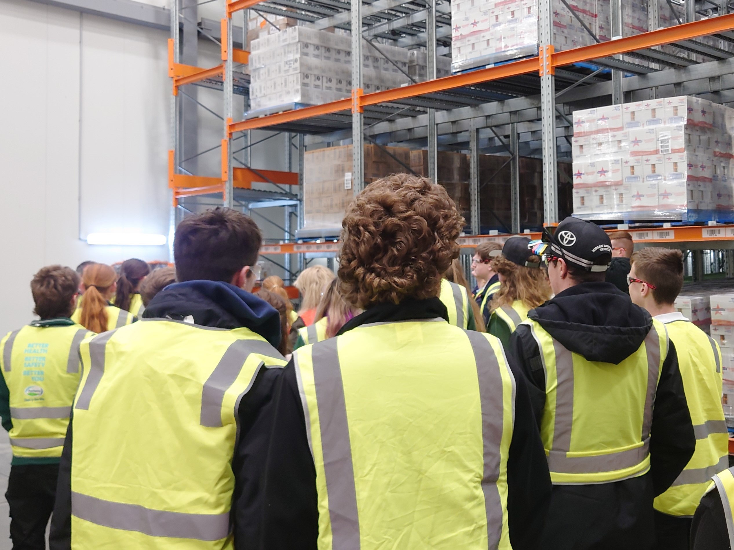 Students in a warehouse wearing high-vis vests